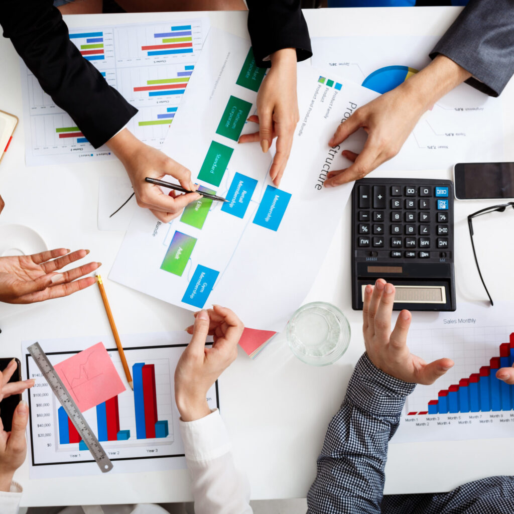 picture of businessmen's hands on white table with documents and drafts